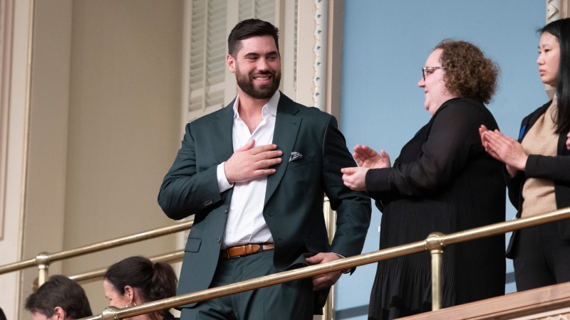 Kansas City Chiefs' Laurent Duvernay-Tardif touches his heart as members of the National Assembly applaud him for his Super Bowl victory, Tuesday, February 18, 2020 at the legislature in Quebec City. THE CANADIAN PRESS/Jacques Boissinot