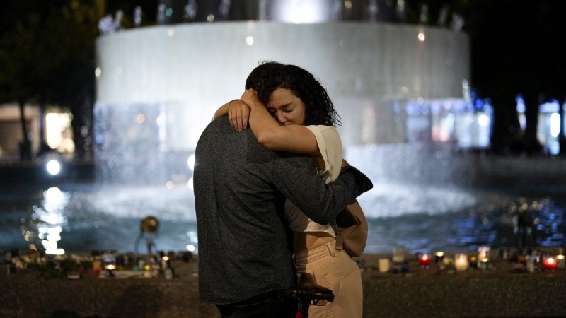 A couple hugs next to candles lighted in honour of victims of the Hamas attacks during a vigil at the Dizengoff square in central Tel Aviv, Israel, Friday, Oct. 13, 2023. (AP Photo/Francisco Seco)

