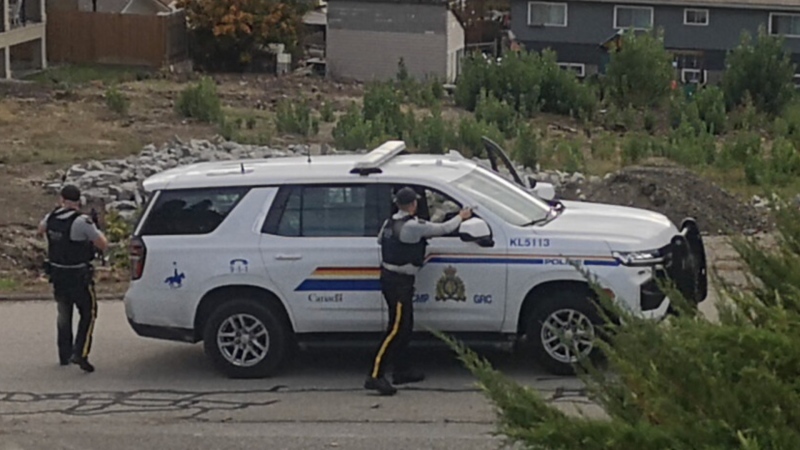 Officers are seen with guns drawn on Skyline Road in West Kelowna Wednesday. (Castanet.net)