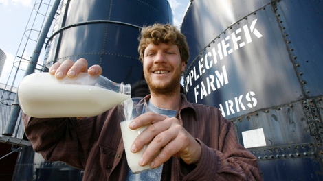 John Clark pours raw milk into a glass at Applecheek Farm in Hyde Park, Vt., in this Monday, June 2, 2008 file photo. (AP / Toby Talbot)