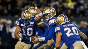 Winnipeg Blue Bombers quarterback Zach Collaros (8) fakes the handoff to Nic Demski (10) and gives it to Brady Oliveira (20) during first half CFL action against the B.C. Lions in Winnipeg Saturday, November 11, 2023. THE CANADIAN PRESS/John Woods