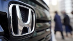 People walk near the logo of Honda Motor Company at a showroom Tuesday, Feb. 8, 2022, in Tokyo.  (AP Photo/Eugene Hoshiko)