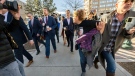 Chrystina Page, right, hold back Heather De Wolf, as she yells at Jon Hallford, left, the owner of Back to Nature Funeral Home, as he leaves with his lawyers following a preliminary hearing, Thursday, Feb. 8, 2024, outside the El Paso County Judicial Building in Colorado Springs, Colo. (Christian Murdock/The Gazette via AP)