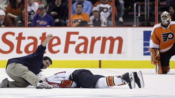 A person signals to the bench after checking on Florida Panthers forward David Booth, who was injured in the second period of an NHL hockey game against the Philadelphia Flyers, Saturday, Oct. 24, 2009. Booth suffered a concussion after a blindside head shot. (AP / Matt Slocum)