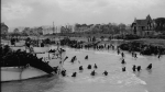 View looking east along 'Nan White' Beach, showing personnel of the 9th Canadian Infantry Brigade landing from LCI(L) 299 of the 2nd Canadian (262nd RN) Flotilla on D-Day. (CP PHOTO) 1998 (National Archives of Canada-Gilbert Alexandre Milne)