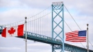 Canadian and American flags fly near the Ambassador Bridge at the Canada/U.S.A. border crossing in Windsor, Ont. on Saturday, March 21, 2020. (THE CANADIAN PRESS/Rob Gurdebeke)