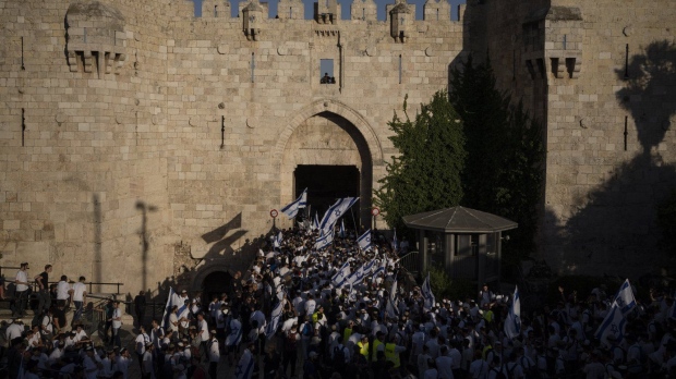Israelis wave national flags during a march marking Jerusalem Day in front of the Damascus Gate of Jerusalem's Old City. (Leo Correa/AP Photo)