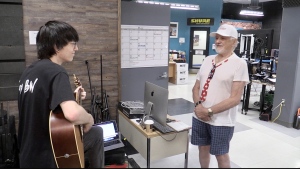 Veteran and lyricist Bruce Stock (right) sings along to his song ‘We Shoot, We Score!’ as it is played acoustically by student Ian Webster inside the Digital Creative Arts Centre in London, Ont. on June 5, 2024. (Sean Irvine/CTV News London)