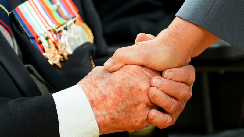 Mary Simon, Governor General and Commander-in-Chief of Canada, holds the hand of veteran Roland Lalonde after presenting him with a poppy during a ceremony to launch the National Poppy Campaign at Rideau in Ottawa, on Tuesday, Oct. 25, 2022. (Sean Kilpatrick / The Canadian Press)