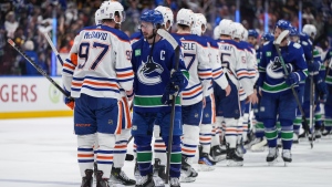 Vancouver Canucks' Quinn Hughes, front right, and Edmonton Oilers' Connor McDavid talk shake hands after Edmonton defeated Vancouver during Game 7 of an NHL hockey Stanley Cup second-round playoff series, in Vancouver, on Monday, May 20, 2024. THE CANADIAN PRESS/Darryl Dyck