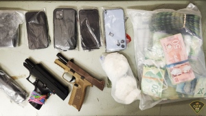 Police seized two 9 mm handguns, ammunition, $25,000 in cash, 300 grams of crack, four grams of fentanyl, oxycodone, four digital scales and 10 cellphones. (OPP photo)