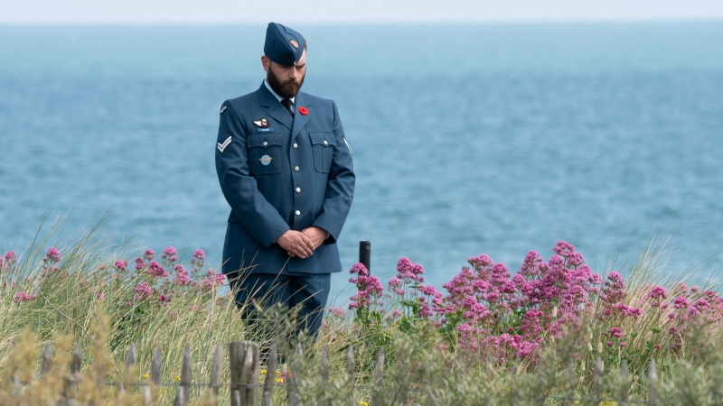 A Canadian Forces member stands on the dunes of Juno Beach commemorating the 80th anniversary of D-Day and the Battle of Normandy, Thursday, June 6, 2024 in Courselles-sur-Mer., France. (Adrian Wyld / The Canadian Press)