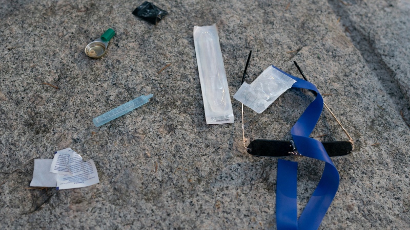 Items are seen on the ground as paramedics from B.C. Ambulance respond to a drug overdose in downtown Vancouver, Wednesday, June 23, 2021. THE CANADIAN PRESS/Jonathan Hayward