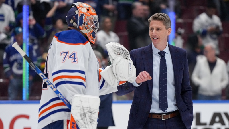 Edmonton Oilers head coach Kris Knoblauch, back right, and goalie Stuart Skinner celebrate after Edmonton defeated the Vancouver Canucks 3-2 during Game 7 of an NHL hockey Stanley Cup second-round playoff series, in Vancouver, on Monday, May 20, 2024. THE CANADIAN PRESS/Darryl Dyck