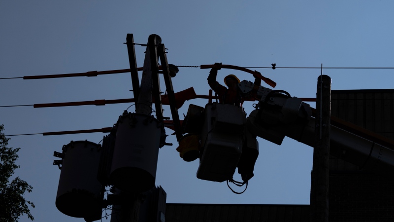 Hydro Quebec workers change a line in a residential neighbourhood in Montreal, Friday, Sept.1, 2023. (Christinne Muschi, The Canadian Press)