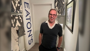 Corey Quintaine stands with the newest part of his Eaton's collection, a sign from the store that he bought off Facebook Marketplace. Uploaded June 6, 2024. (Jamie Dowsett/CTV News Winnipeg)