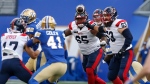 Montreal Alouettes' Joshua Donovan (65), quarterback Cody Fajardo (second right) and Philippe Gagnon (53) look on as Winnipeg Blue Bombers' Brian Cole (41) intercepts the pass during first half CFL action in Winnipeg Thursday, June 6, 2024.THE CANADIAN PRESS/John Woods