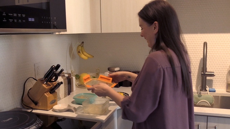 Amanda Kroetsch prepares food at her new apartment in Kitchener on June 7, 2024. (Colton Wiens/CTV News)