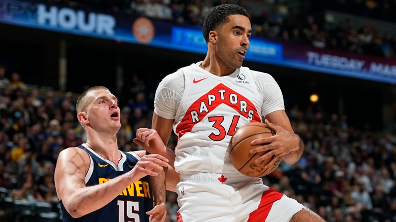Toronto Raptors centre Jontay Porter, right, pulls in a rebound as Denver Nuggets centre Nikola Jokic, left, defends in the first half of an NBA basketball game Monday, March 11, 2024, in Denver. (AP Photo/David Zalubowski) 