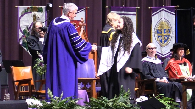 Diana El-Baraqouni, a Western University graduate, wearing a Kuffiyeh (a sign of solidarity with Palestinians) as she walks across the stage at Western’s convocation ceremony on June 10, 2024. (Reta Ismail/CTV News London)  