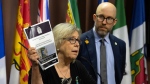 Green Party MP Mike Morrice looks on as leader Elizabeth May speaks while holding up a copy of a public security report during a news conference, in Ottawa, Tuesday, June 11, 2024. THE CANADIAN PRESS/Adrian Wyld 