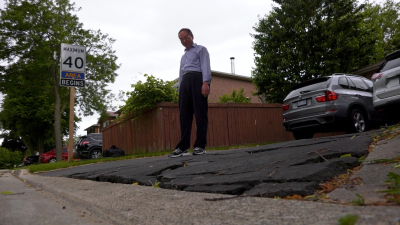 Homeowner Jun Shu stands on his driveway in Mississauga after a paving company impersonating Royal Town Construction dug into it.