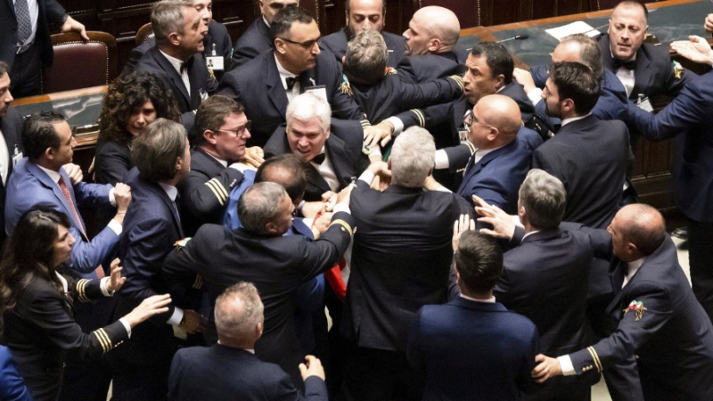 5-Star Movement lawmaker Leonardo Donno, center top, is protected by parliament employees from other lawmakers during brawl in the lower chamber of deputies at the Italian parliament, in Rome, Wednesday, June 12, 2024. (Mauro Scrobogna/LaPresse via AP)