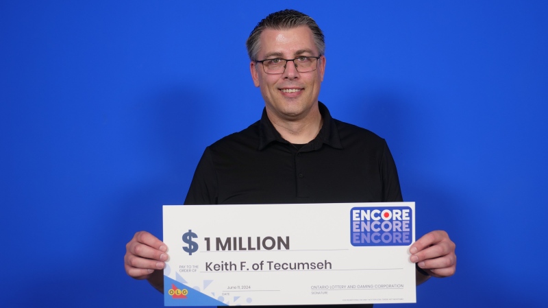 Keith Ford of Tecumseh collects his $1-million cheque. (Source: OLG)