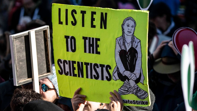 A climate activist holds up a sign during a protest in Vancouver, B.C., in October 2019. 