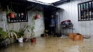 A woman stands in the doorway of her flooded house after heavy storms in Curanilahue, Chile, Thursday, June 13, 2024. (AP Photo/Amilix Fornerod)