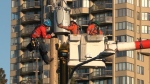 Crews fix damage to a power line after a crash in Burnaby on June 13, 2024.