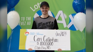 Cory Callaghan holds a $1 million cheque from Atlantic Lottery.