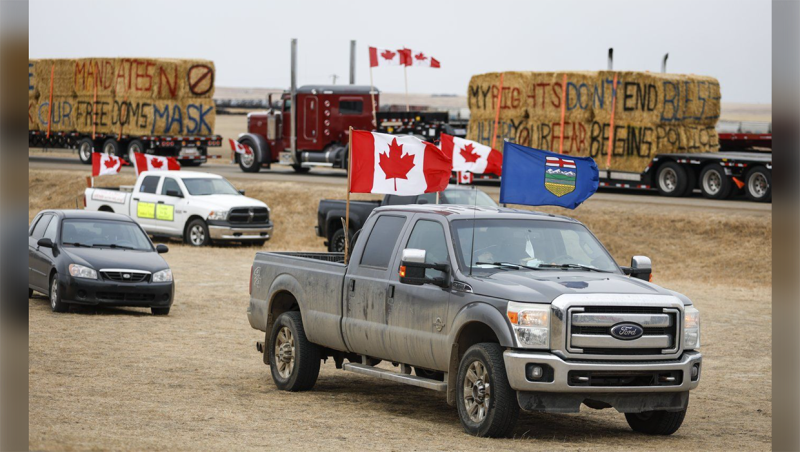 Anti-mandate demonstrators gather as a truck convoy blocks the highway the busy U.S. border crossing in Coutts, Alta., Monday, Jan. 31, 2022. A second RCMP officer who went undercover as a supporter at the Coutts, Alta., blockade in 2022 has testified that one of two men charged with conspiracy to commit murder said all police officers at the blockade "should be hung." THE CANADIAN PRESS/Jeff McIntosh