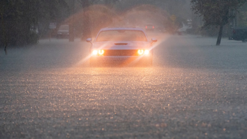 A driver blinks their hazard lights as heavy rain falls over parts of South Florida on Wednesday, June 12, 2024, in Hollywood, Fla. (Source: Matias J. Ocner/Miami Herald via AP)