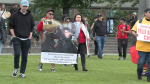 People hold signs in the third annual march for missing and murdered Indigenous men, boys and two-spirit-plus people in Vancouver, B.C., on June 14, 2024.