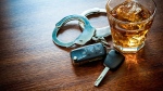 A pair of handcuffs and a set of car keys next to a drink. (File photo/GettyImages) 