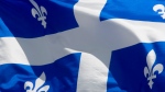 Quebec's provincial flag flies on a flagpole in Ottawa on June 30, 2020. (Adrian Wyld/The Canadian Press)