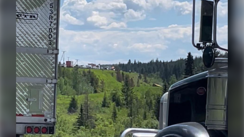 A photo posted on social media shows a yellow school bus down an embankment off Highway 97 near Lac La Hache, B.C., on June 21, 2024. (Facebook)