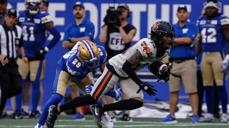 Winnipeg Blue Bombers' Marquise Bridges (29) tries to stop B.C. Lions' Alexander Hollins (13) during second half CFL action in Winnipeg, Friday, June 21, 2024. (John Woods/The Canadian Press)