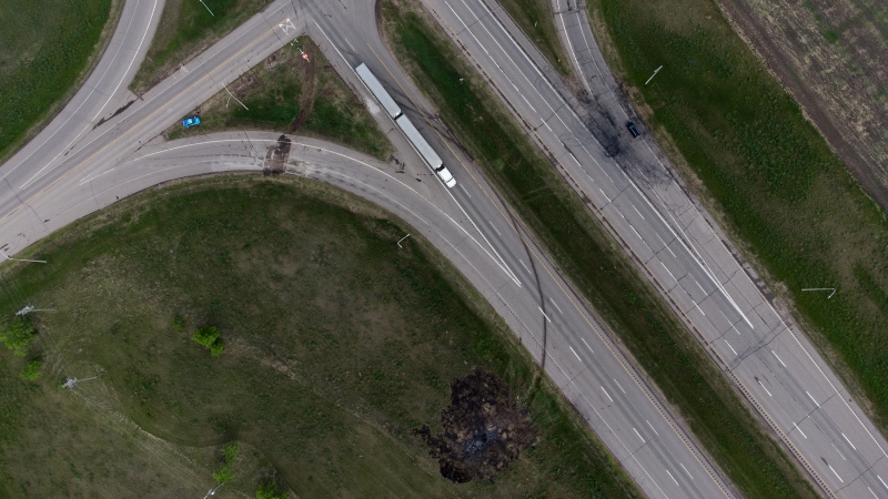 A scorched patch of ground where a bus carrying seniors ended up after colliding with a transport truck and burning on June 15, 2023 is seen on the edge of the Trans-Canada Highway where it intersects with Highway 5, west of Winnipeg near Carberry, Man., one day later. (Darryl Dyck/The Canadian Press)