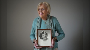 Vi Roden, who turned 101 on June 16, holds a photo of herself when she was 17, while posing for a photograph at her home in West Vancouver, on Friday, June 14, 2024. (Darryl Dyck / The Canadian Press)