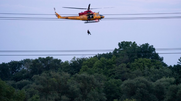 A Royal Canadian Air Force Search and Rescue helicopter crew rescues a man from Etobicoke Creek following heavy rain in Toronto on Tuesday, July 16, 2024. Torrential rain that pummelled Toronto flooded a major highway, several thoroughfares and a key transit hub on Tuesday – requiring emergency crews to rescue people from stranded cars and other spaces – while large parts of the city were left without power. THE CANADIAN PRESS/Arlyn McAdorey