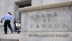 A worker rolls signs past the Bank of Canada, Wednesday, April 10, 2024 in Ottawa. THE CANADIAN PRESS/Adrian Wyld