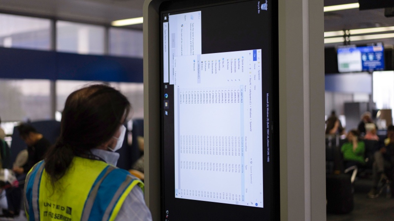 A technician works on an information display near United Airlines gates at Chicago O'Hare International Airport in Chicago, Friday, July 19, 2024, after a faulty CrowdStrike update caused a major internet outage for computers running Microsoft Windows. (Carolyn Kaster / AP Photo)