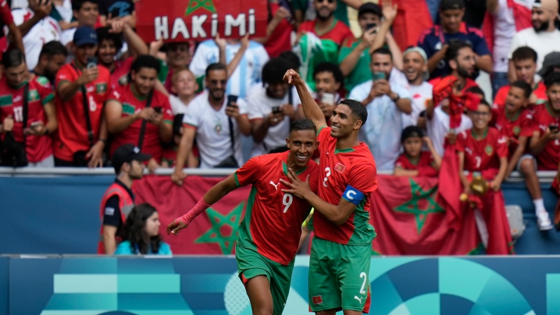 Morocco's Soufiane Rahimi, left, is congratulated by Achraf Hakimi after scoring his 2nd goal during the soccer match between Argentina and Morocco at the 2024 Summer Olympics, Wednesday, July 24, 2024, in Saint-Etienne, France. (Silvia Izquierdo / AP Photo)