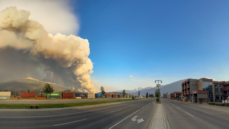 A wildfire burns as an empty street in Jasper, Alta. is shown in this Wednesday, July 24, 2024 handout photo from the Jasper National Park Facebook page. (THE CANADIAN PRESS/HO, Facebook, Jasper National Park)