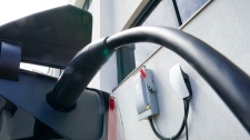 An electric vehicle is charged in Ottawa on Wednesday, July 13, 2022. Canada and the U.S. are teaming up to build a corridor of charging stations between Quebec City and Michigan to encourage motorists in both countries to buy more electric vehicles. (Sean Kilpatrick, The Canadian Press)