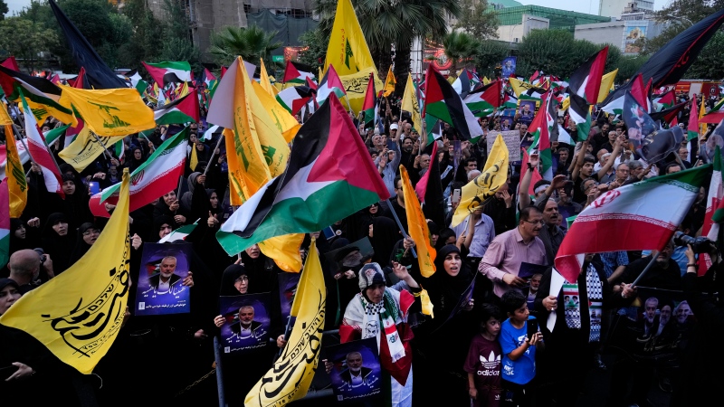 Iranian protesters wave Iranian, Palestinian and Lebanon's militant Hezbollah group flags in a demonstration to condemn the killing of Hamas leader Ismail Haniyeh, at Felestin (Palestine) Sq. in Tehran, Iran, Wednesday, July 31, 2024. (Vahid Salemi / AP Photo)