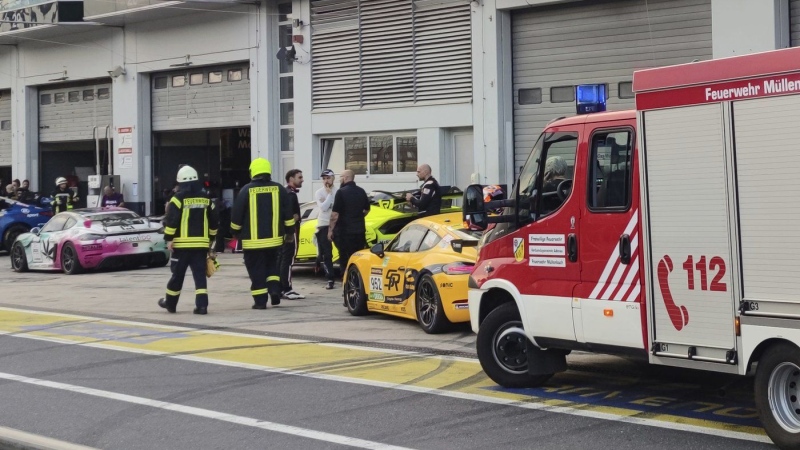 Firefighters walk in front of pit 27 in the pit lane of the Nuerburgring auto racing circuit, in Nuerburgring, Germany, on Friday, Aug. 2, 2024.  (S'nke Brederlow/dpa via AP)