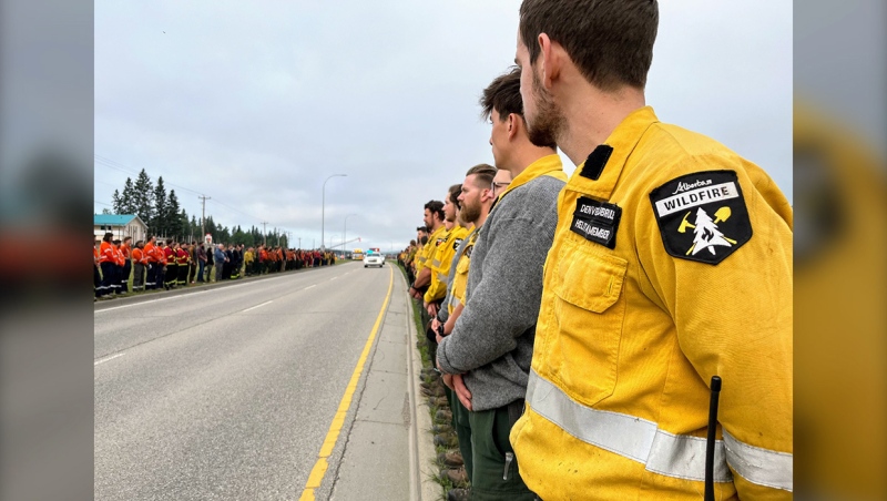 Alberta Wildlife members line the road to pay their respects to their colleague, a 24-year-old Calgary man who was killed by a falling tree northeast of Jasper on Saturday. (Photo: X@AlbertaWildfire)